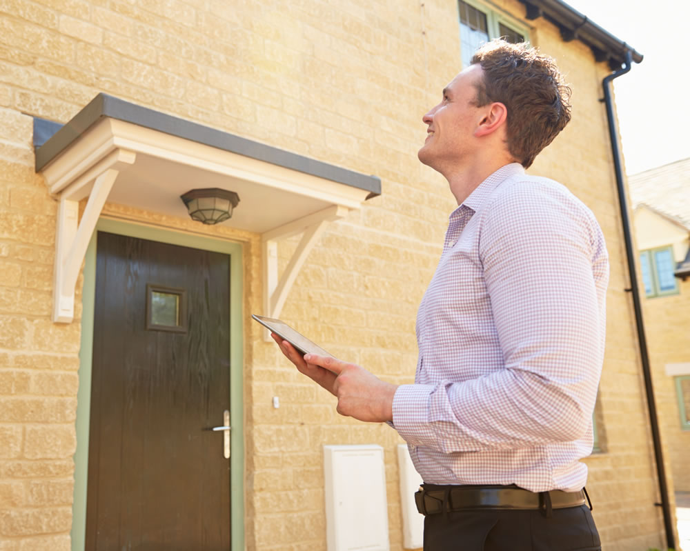 Man outside property carrying out assessment